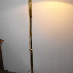 Mosiężna lampa podłogowa z ruchomym ramieniem.